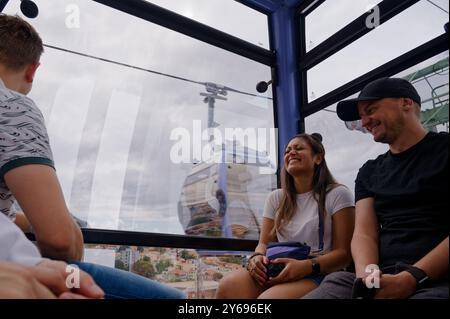 I turisti sorridenti si godono il giro in funivia di funchal, ammirando le viste mozzafiato di Madeira Foto Stock