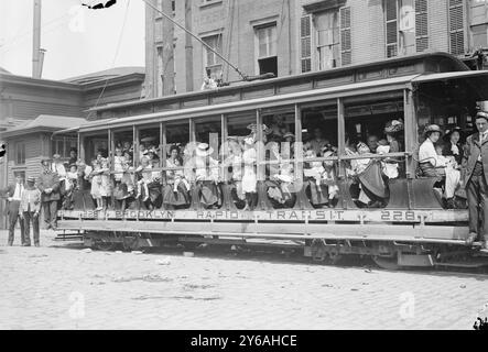 Escursione all'aria aperta, foto mostra probabilmente le madri e i loro figli in tram diretti a un traghetto che li ha portati a Sea Breeze, Coney Island, in un viaggio sponsorizzato dalla Fresh Air Home della New York Association for Improving the Condition of the Poor., 1913 giugno 2, Glass negative, 1 negative: Glass; 5 x 7 in. o più piccolo. Foto Stock