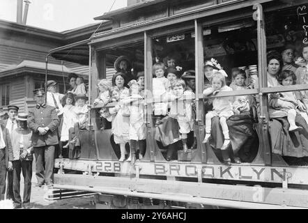 Escursione in aria fresca, foto mostra probabilmente le madri e i loro figli in tram diretto al traghetto che li ha portati a Sea Breeze, Coney Island, in un viaggio sponsorizzato dalla Fresh Air Home della New York Association for Improving the Condition of the Poor., 1913 giugno 2, Glass negative, 1 negative: Glass; 5 x 7 pollici. o più piccolo. Foto Stock