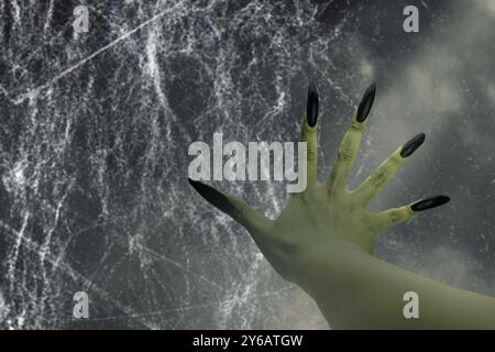 Mano delle streghe con un lungo artiglio per unghie. Il colore è verde. Il male, gli zombie o la mano del mostro sono mostrati in una stanza buia. La scena è inquietante e inquietante. Lepre Foto Stock