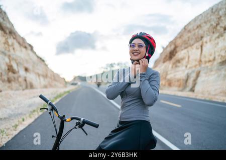 ciclista hijab che indossa il casco per sicurezza Foto Stock