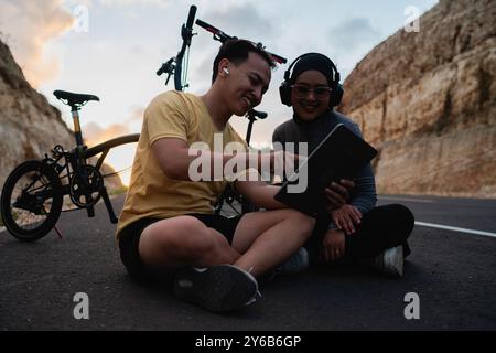 motociclista uomo che presenta tablet digitale partner femminile Foto Stock