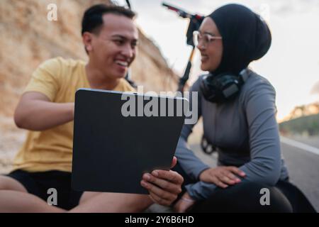 coppia ciclistica atletica che usa un tablet Foto Stock