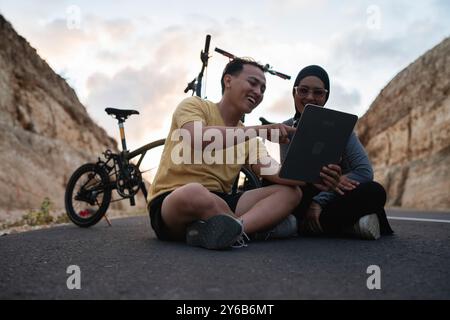uomo biker e amico hijab che si riposa e usa un tablet Foto Stock