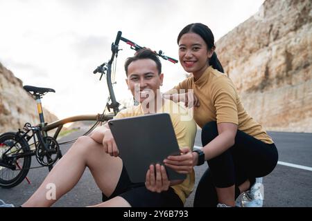 potrait sorridente motociclista femminile e maschile con tablet Foto Stock