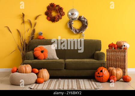Elegante soggiorno con ballo da discoteca e divano verde decorato per la festa di Halloween Foto Stock
