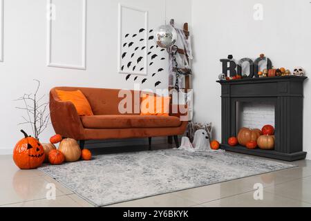Elegante soggiorno con ballo da discoteca e divano marrone decorato per la festa di Halloween Foto Stock