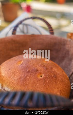 Impasto naturale fresco. Pane rotondo di pasta madre artigianale appena sfornata. Niente pane impastato. Pane fatto in casa in un cestino. Tradizionale cru appena sfornato Foto Stock