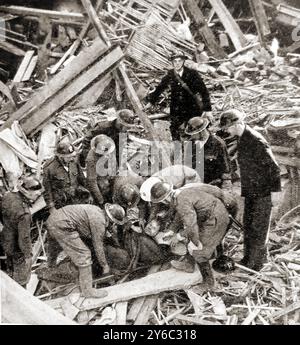 Seconda Guerra Mondiale - Una squadra di soccorso a Londra che recupera una vittima da un edificio bombardato. - Seconda Guerre mondiale - Une équipe de secours à Londres récupère une victime d'un immeuble bombardé. - Zweiter Weltkrieg – Ein Rettungsteam a Londra birgt einen Verletzten aus einem bombardierten Gebäude. - Foto Stock