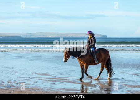 Dunnet, Scozia, Regno Unito - 9 novembre 2023: Cavaliere in sella a un cavallo a Dunnet Beach nelle Highlands scozzesi settentrionali, Caithness, Scozia, Regno Unito Foto Stock