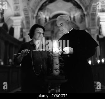 CELEBRAZIONI PER I DIRITTI UMANI ALLA CHIESA DI ST BRIDE - FILO SPINATO CANDELA EMESHED ACCESA CON ANNELIE BRANDTAND REVERENDO DEWI MORGAN A LONDRA / ; 10 DICEMBRE 1963 Foto Stock