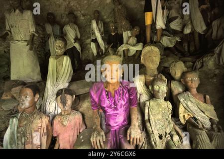 Il legno effige all'interno di una grotta in un sito di sepoltura tradizionale nel villaggio di Kete Kesu, Toraja Nord, Sulawesi Sud, Indonesia. Foto Stock