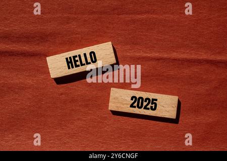 Messaggio Hello 2025 scritto su blocchi di legno con sfondo marrone. Simbolo ciao 2025 concettuale. Copia spazio. Foto Stock