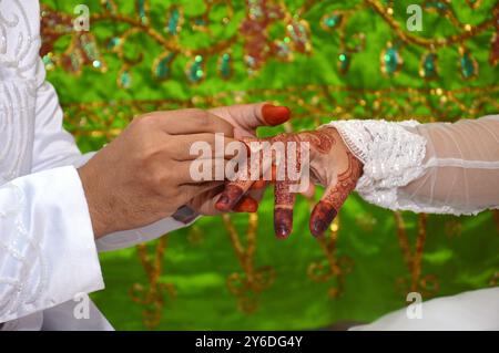 Mettere l'anello nuziale al dito del matrimonio indonesiano sposa Foto Stock