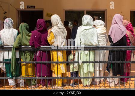 Le elettori del Kashmir attendono in coda per votare fuori dal seggio elettorale durante la seconda fase delle elezioni dell'assemblea del Jammu e del Kashmir a Budgam, a sud-ovest di Srinagar. Queste sono le prime elezioni dell'assemblea locale in un decennio e le prime da quando nuova Delhi ha revocato lo status semi-autonomo della regione nel 2019, ponendola sotto il dominio diretto. Quasi nove milioni di persone sono registrate per votare nella regione contesa, tradizionalmente nota per i boicottaggi contro il governo indiano. (Foto di Faisal Bashir/SOPA Images/Sipa USA) Foto Stock