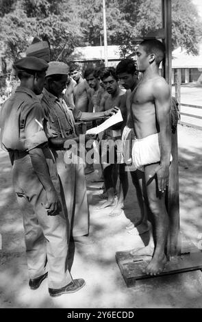 LE RECLUTE DELL'ESERCITO ATTENDONO UN ESAME FISICO A NUOVA DELHI; 16 NOVEMBRE 1962 Foto Stock