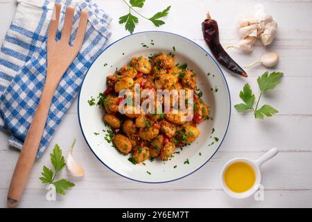 Deliziosi gnocchi italiani con pesto rosso. Tavolo con vista dall'alto e decorazioni. Foto Stock