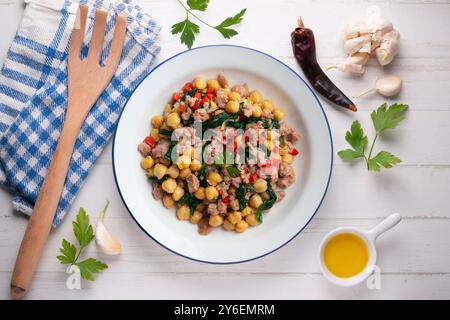 Salsiccia di maiale catalana con ceci e spinaci. Tavolo con vista dall'alto e decorazioni. Foto Stock