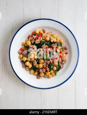 Salsiccia di maiale catalana con ceci e spinaci. Tavolo con vista dall'alto e decorazioni. Foto Stock