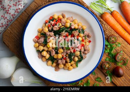 Salsiccia di maiale catalana con ceci e spinaci. Tavolo con vista dall'alto e decorazioni. Foto Stock