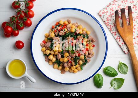 Salsiccia di maiale catalana con ceci e spinaci. Tavolo con vista dall'alto e decorazioni. Foto Stock