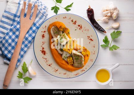 Delizioso pesce sogliola con crema di carote e mais. Tavolo con vista dall'alto e decorazioni. Foto Stock