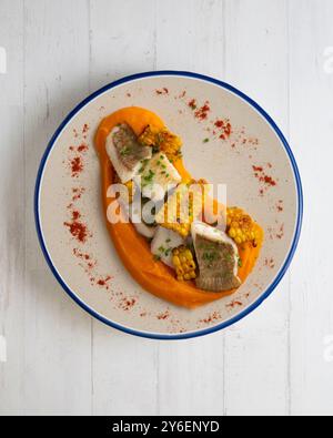 Delizioso pesce sogliola con crema di carote e mais. Tavolo con vista dall'alto e decorazioni. Foto Stock