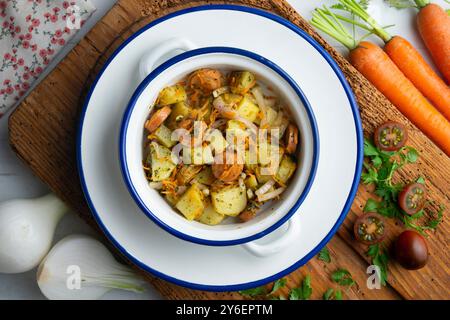 Insalata sana di patate, cipolle e salsicce. Tavolo con vista dall'alto e decorazioni. Foto Stock