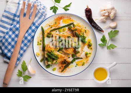 Pesce spada alla griglia con asparagi verdi. Tavolo con vista dall'alto e decorazioni. Foto Stock