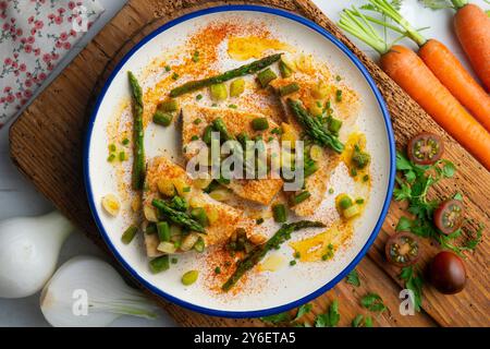 Pesce spada alla griglia con asparagi verdi. Tavolo con vista dall'alto e decorazioni. Foto Stock