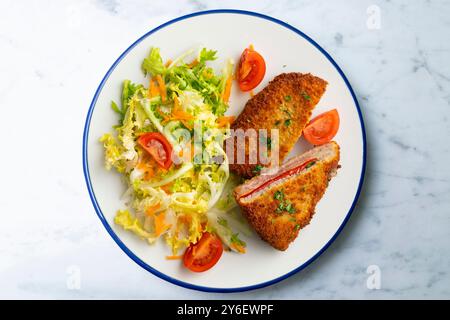 Cachopo asturiano. Filetto di manzo impanato ripieno di formaggio e pepe. Tavolo con vista dall'alto e decorazioni. Foto Stock