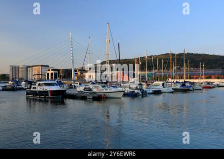Yacht ormeggiato sul fiume Tawe con la SA1 sviluppo nella distanza, Swansea, South Wales, Regno Unito. Foto Stock