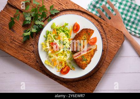 Cachopo asturiano. Filetto di manzo impanato ripieno di formaggio e pepe. Tavolo con vista dall'alto e decorazioni. Foto Stock