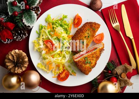 Cachopo asturiano. Filetto di manzo impanato ripieno di formaggio e pepe. Tavolo con vista dall'alto e decorazioni natalizie. Foto Stock