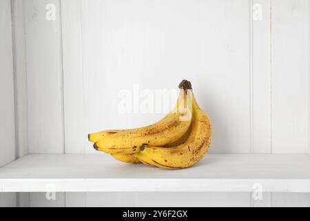 Mucchio di banane mature con macchie scure sullo scaffale Foto Stock