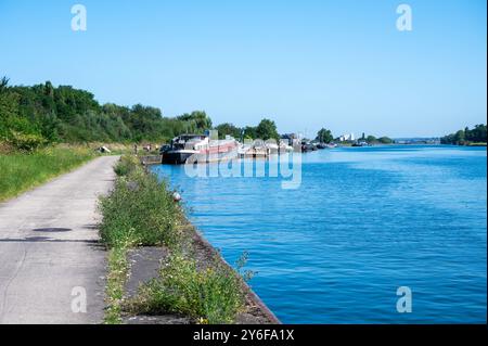 Oupeye, Liegi, Belgio, 11 agosto 2024 - pista ciclabile sulle rive industriali del fiume Maas Foto Stock