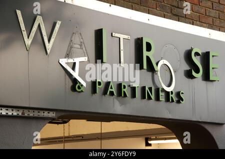 Waitrose e Partners sono rotti e trascurati, cadono a pezzi con lettere appese. Vista sopra l'ingresso del parcheggio del supermercato. Inghilterra, Regno Unito. Foto Stock