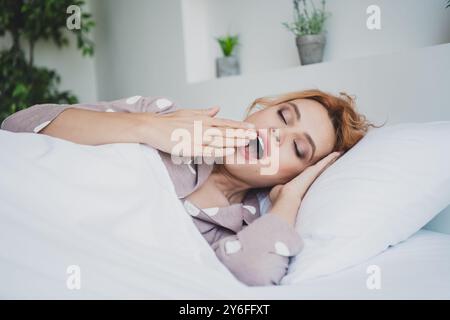 Foto di adorabili cameriere che sorridono godendo del weekend sbadigliando casa in camera interna Foto Stock