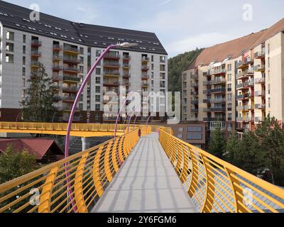 Sinaia, Romania - 25 settembre 2024 - Ponte pedonale giallo vibrante che collega i quartieri. Foto Stock