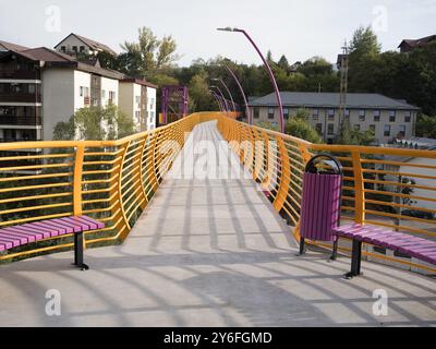 Sinaia, Romania - 25 settembre 2024 - Ponte pedonale giallo vibrante che collega i quartieri. Foto Stock