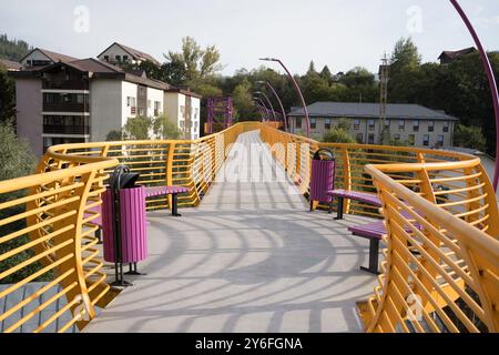 Sinaia, Romania - 25 settembre 2024 - Ponte pedonale giallo vibrante che collega i quartieri. Foto Stock