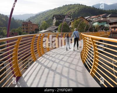 Sinaia, Romania - 25 settembre 2024 - Ponte pedonale giallo vibrante che collega i quartieri. Foto Stock