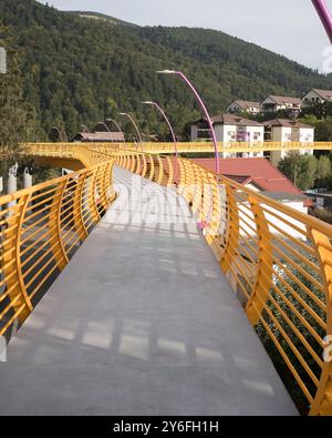 Sinaia, Romania - 25 settembre 2024 - Ponte pedonale giallo vibrante che collega i quartieri. Foto Stock