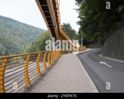 Sinaia, Romania - 25 settembre 2024 - Ponte pedonale giallo vibrante che collega i quartieri. Foto Stock