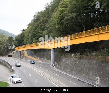 Sinaia, Romania - 25 settembre 2024 - Ponte pedonale giallo vibrante che collega i quartieri. Foto Stock