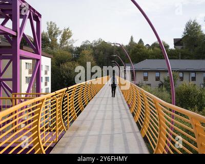 Sinaia, Romania - 25 settembre 2024 - Ponte pedonale giallo vibrante che collega i quartieri. Foto Stock