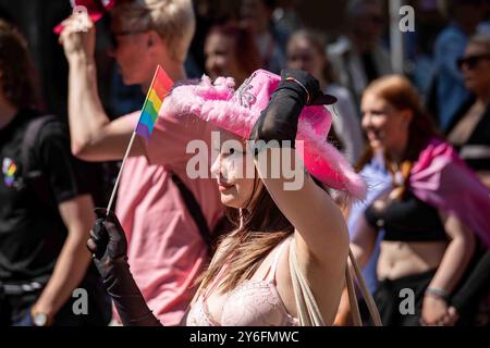 Giovane donna che indossa un reggiseno rosa e un cappello da cowboy rosa alla parata Helsinki Pride 2024 su Mannerheimintie a Helsinki, Finlandia Foto Stock