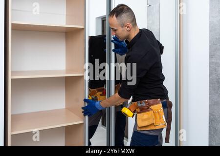 L'uomo è impegnato nella riparazione e montaggio di mobili Foto Stock