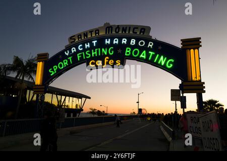 La folla si riunisce sotto il cartello del porto degli yacht di Santa Monica, godendosi una giornata di ristoranti all'aperto, pesca sportiva e nautica lungo il pittoresco lungomare. Foto Stock