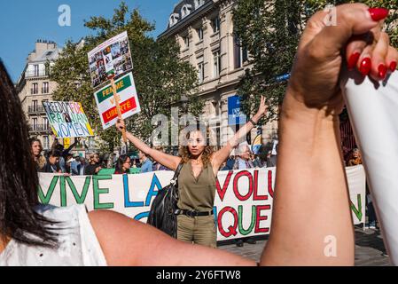 Una donna alla fine della manifestazione con un cartello, Woman Life Free, un movimento internazionale per l'emancipazione femminile. Davanti allo striscione, lunga vita alla rivoluzione democratica in Iran. Donna vita libertà. Manifestazioni in occasione di due anni dall'assassinio di Jina Mahsa Amini, avvenuto il 16 settembre 2022 a Teheran, e per sostenere il popolo iraniano nella sua ricerca della libertà, della laicità e della democrazia. Francia, Parigi, 15 settembre 2024. Foto di Patricia Huchot-Boissier / Agence DyF. Foto Stock